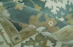 Detailed view of the olive and cream floral borders on a custom size teal rug.